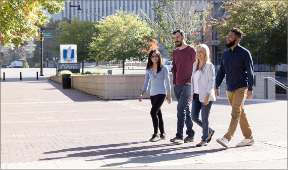 Four people walking outside with Nationwide headquarters in the background