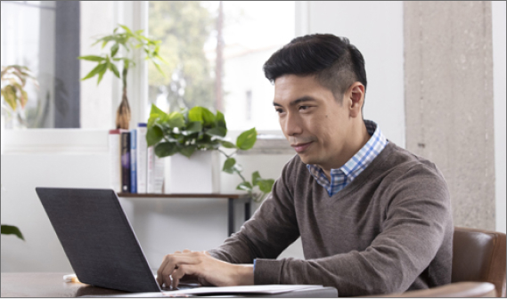 Man sitting and looking at a laptop.